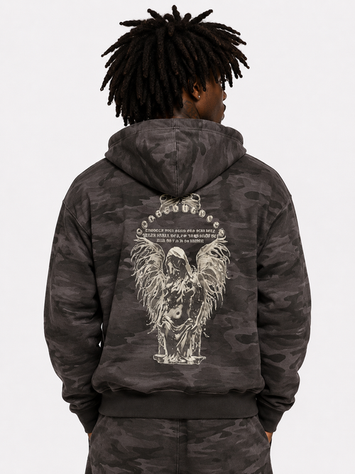 Person wearing a dark camouflage hoodie with an angel design on the back against a white background