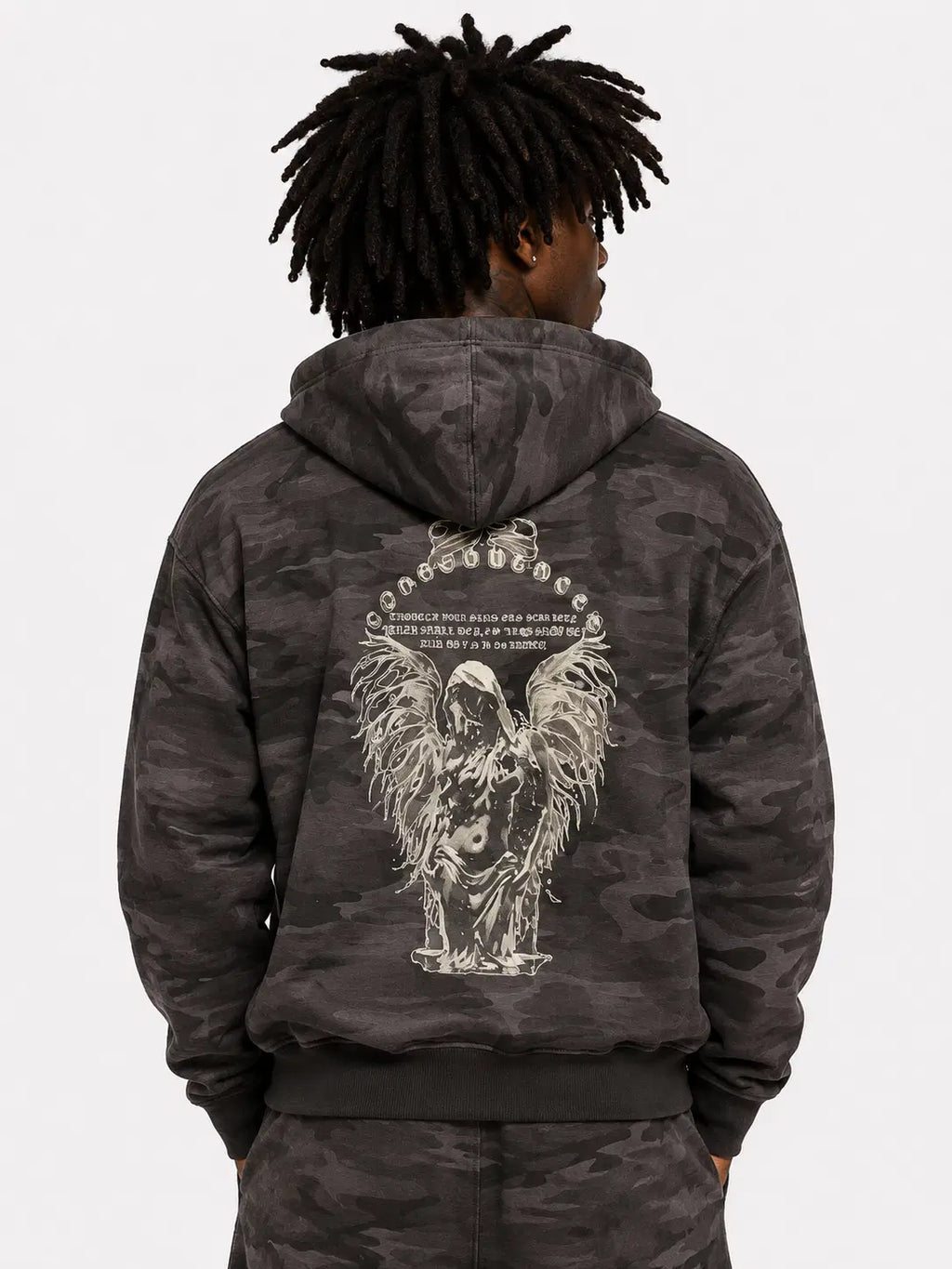 Person wearing a dark camouflage hoodie with an angel design on the back against a white background