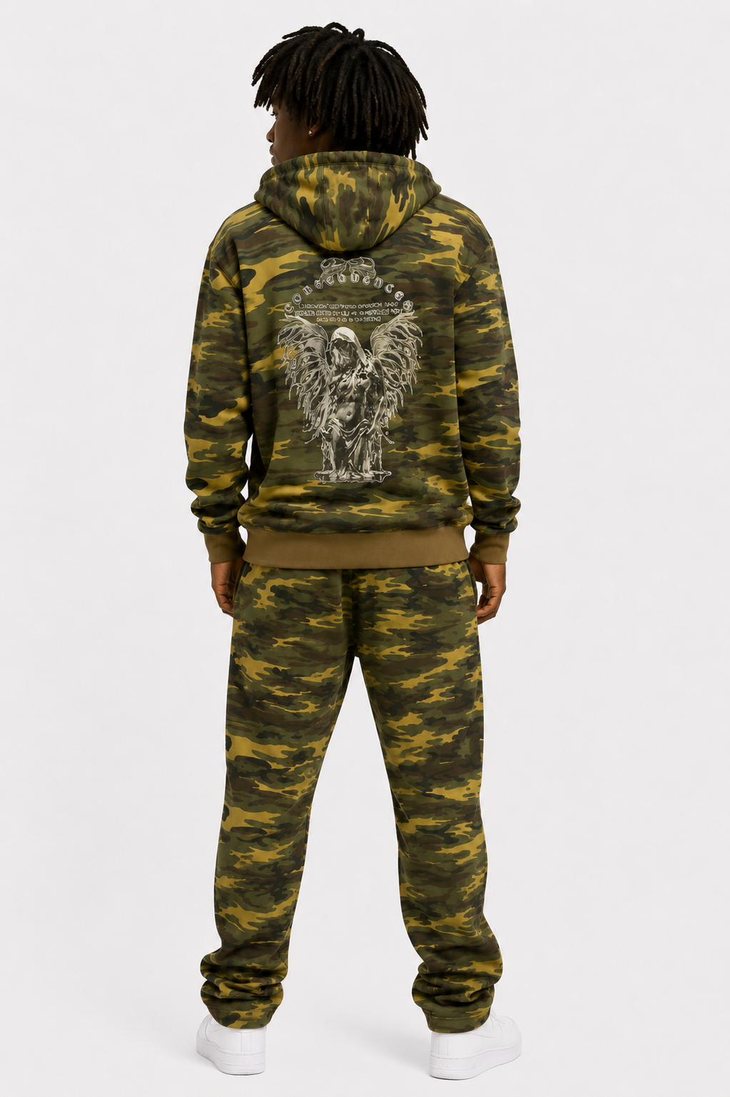 Person wearing a camouflage hoodie and pants set with a design on the back, standing against a white background.