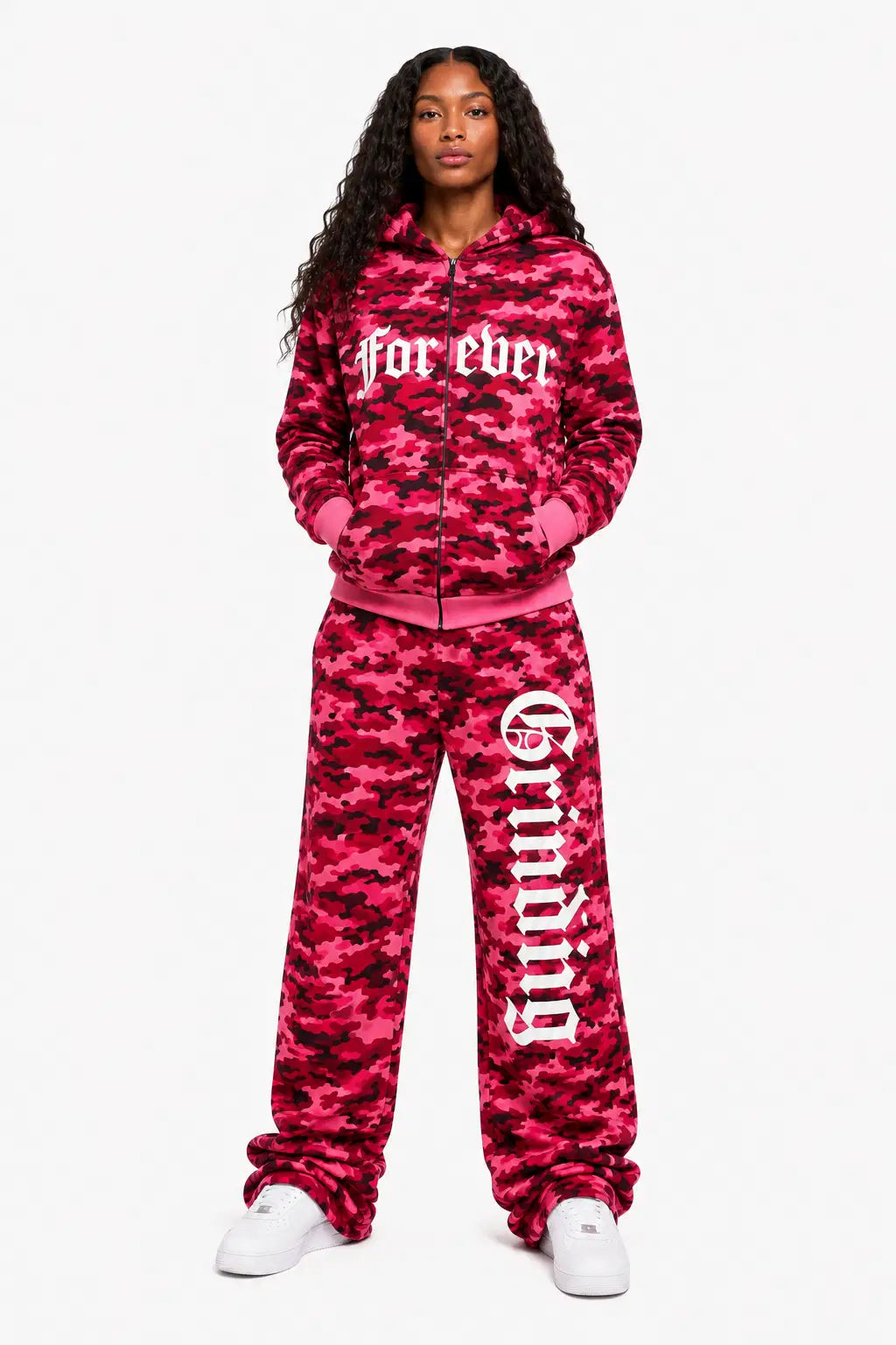 Person wearing a pink camouflage tracksuit with text on a white background
