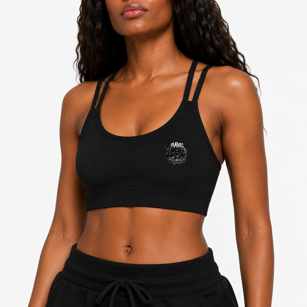 Woman wearing a black sports bra with a logo on a plain background