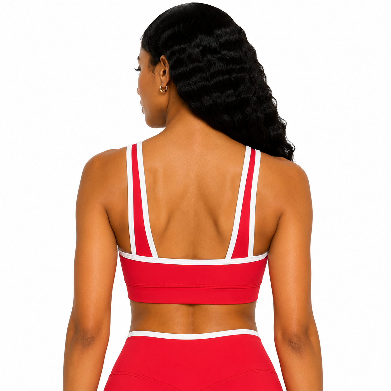 Woman wearing a red sports bra and leggings set on a white background