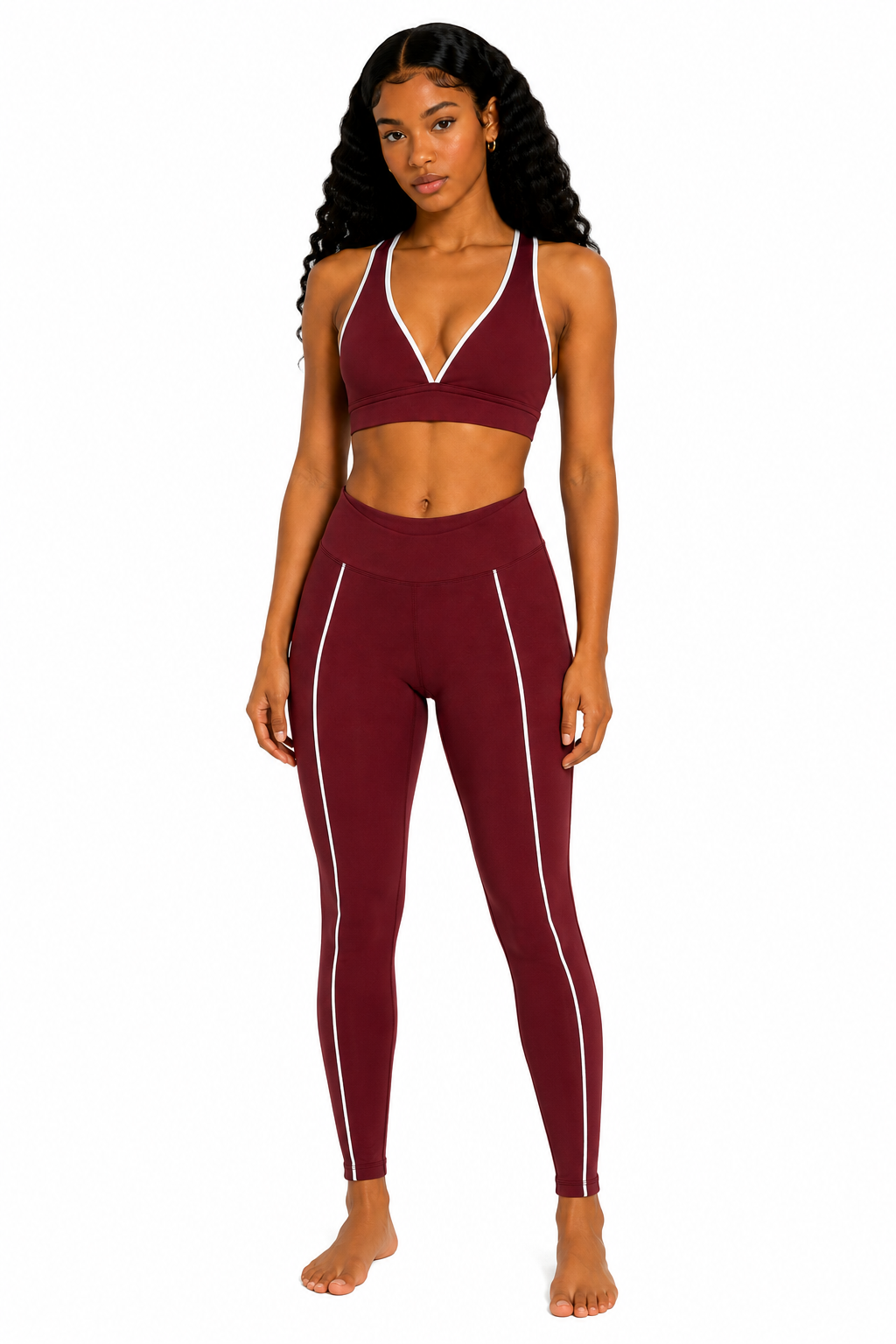 Woman wearing a maroon sports bra and leggings set on a white background