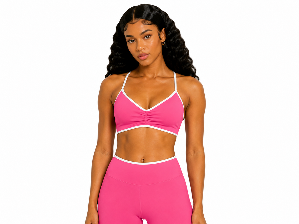 Woman wearing a pink sports bra and leggings on a white background