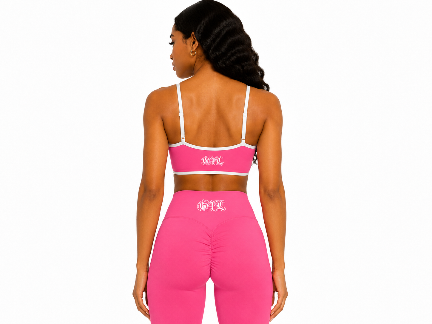 Woman wearing a pink sports bra and leggings with a brand logo on a white background