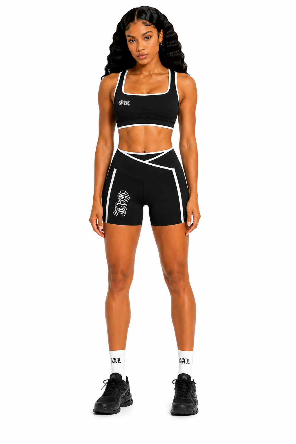 Woman wearing a black sports bra and shorts set with visible branding on a white background