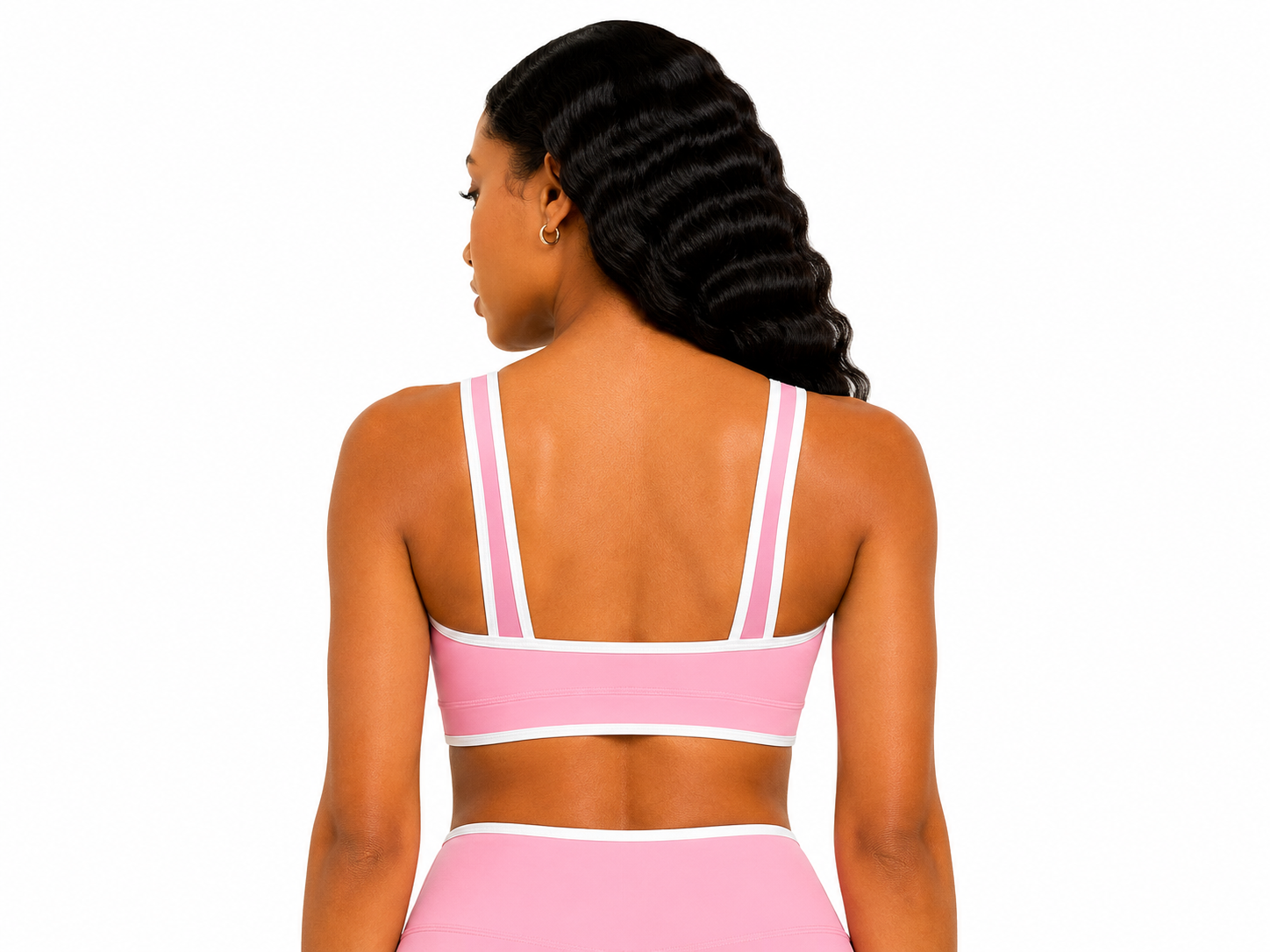 Woman wearing a pink sports bra and leggings on a white background