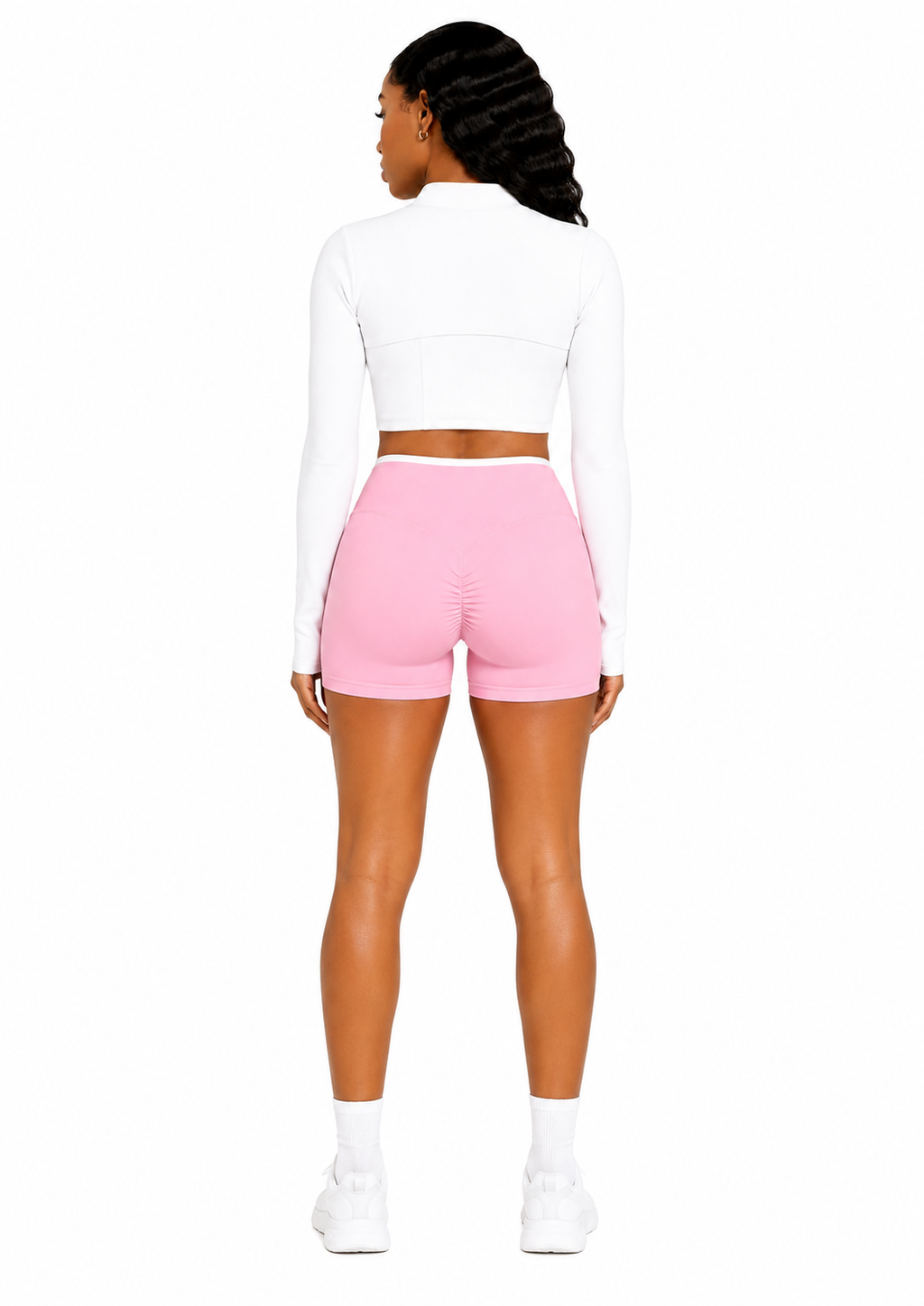 Person wearing a white long-sleeve top and pink shorts on a white background