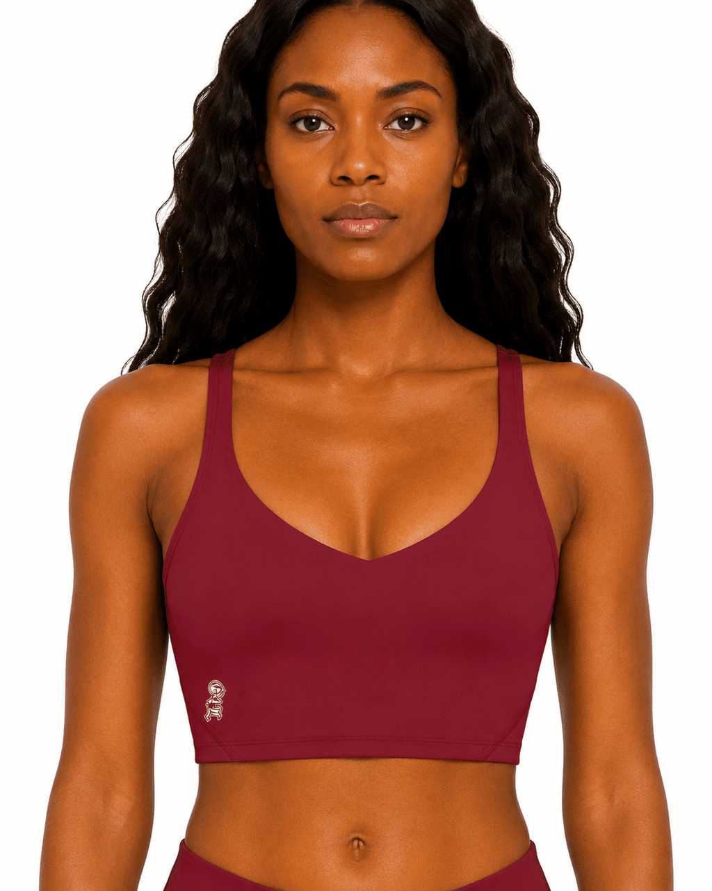 Woman wearing a maroon sports bra on a white background