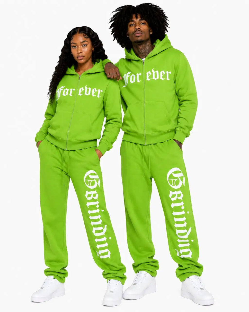 Two people wearing matching green tracksuits with text on a white background
