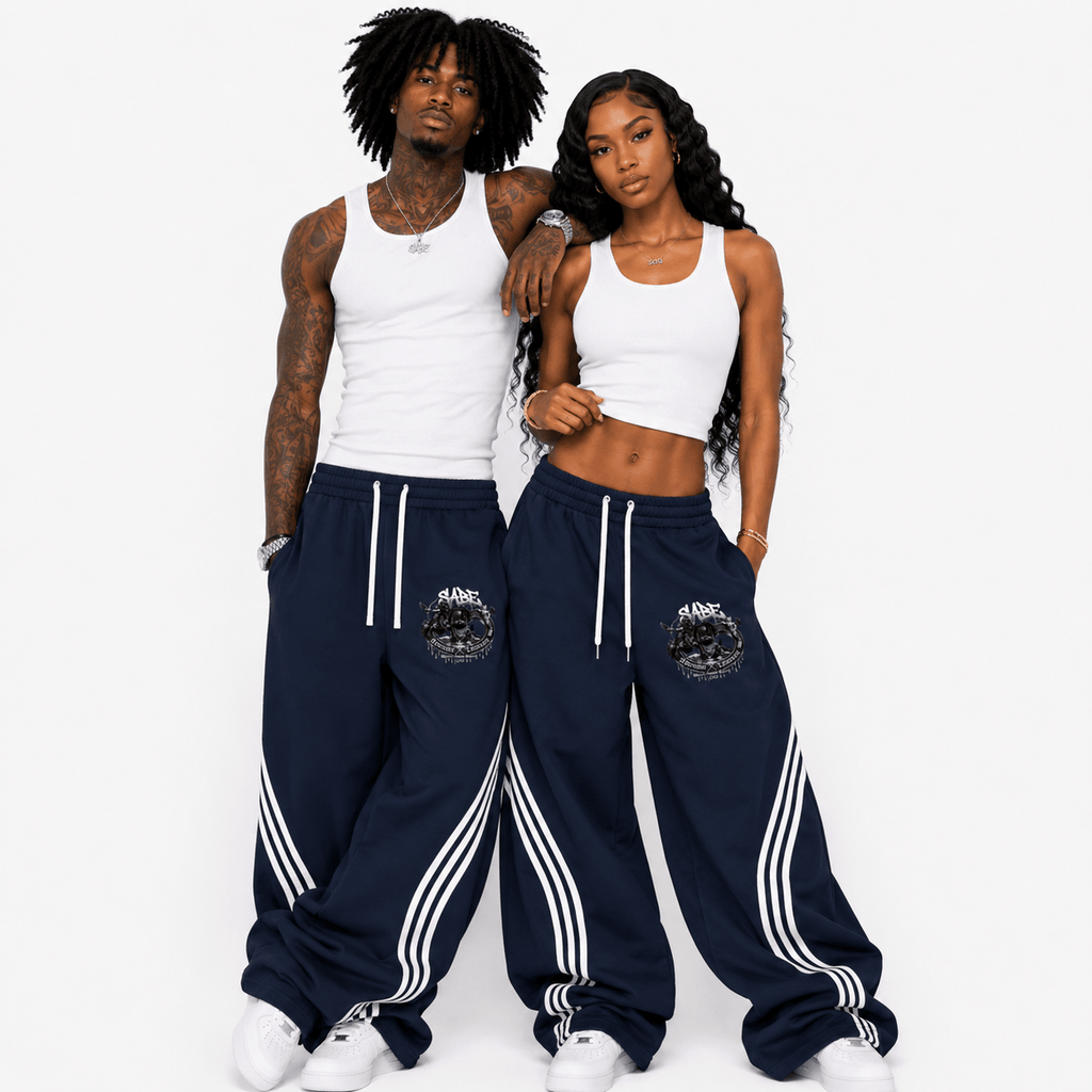 Two people wearing matching navy tracksuits with white stripes on a white background