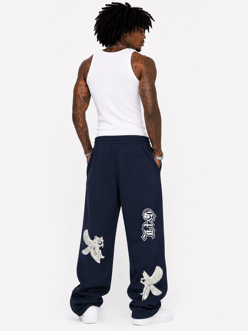 Person wearing navy sweatpants with white designs and text on a white background