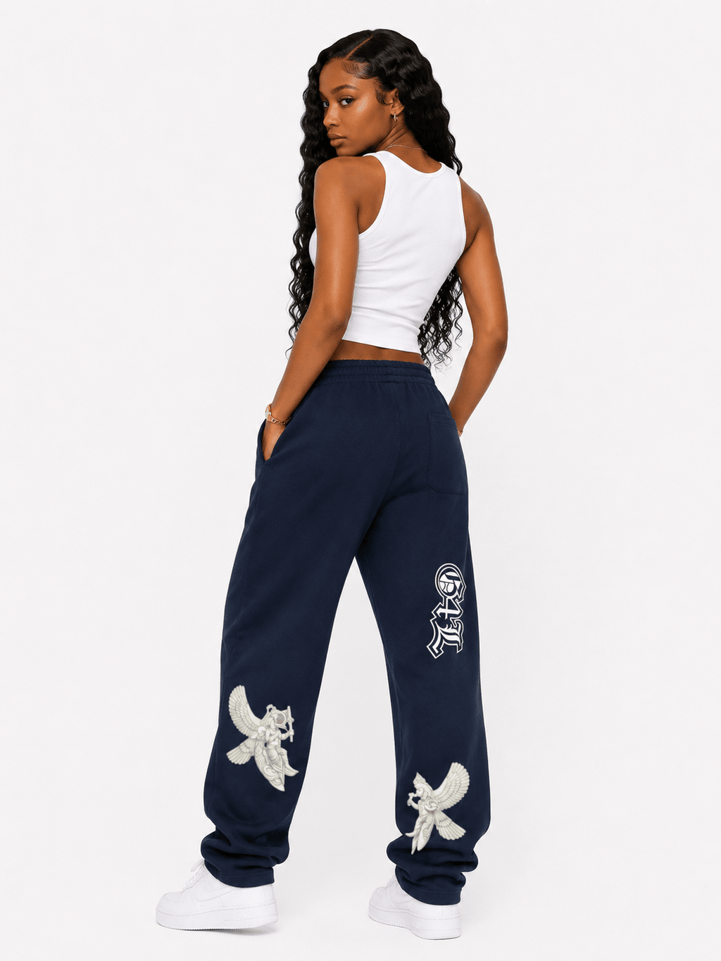 Woman wearing navy sweatpants with white designs on a white background