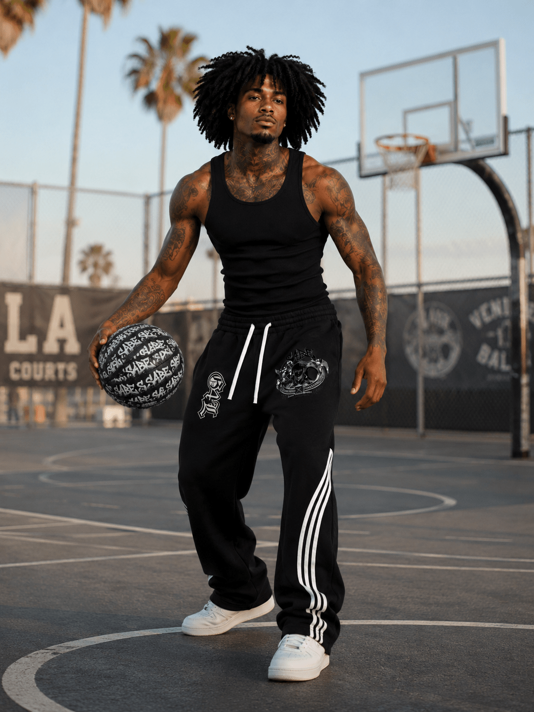 Person holding a basketball on a court with palm trees in the background