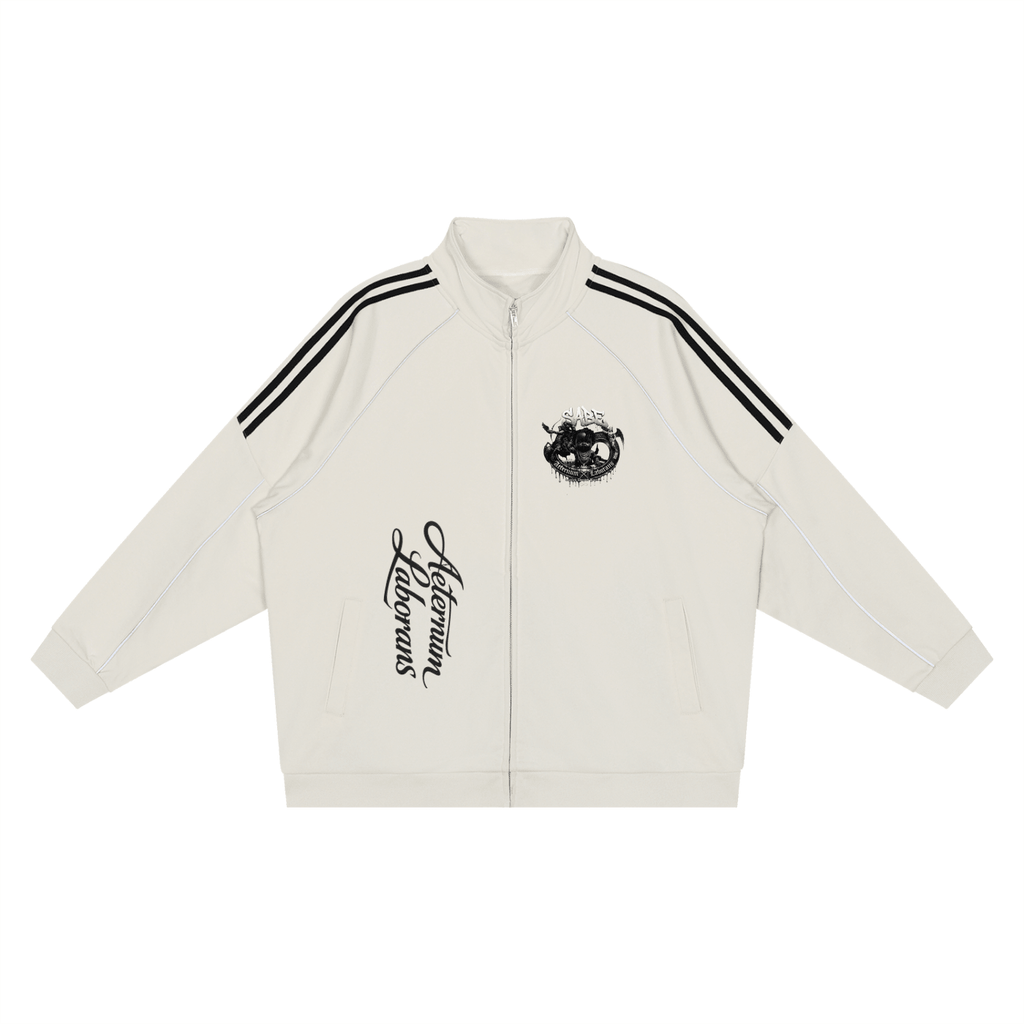 An off-white zip-up track jacket with black double stripes on the shoulders, a black graphic on the left chest, and vertical black script text on the right chest, displayed flat against a white background.
