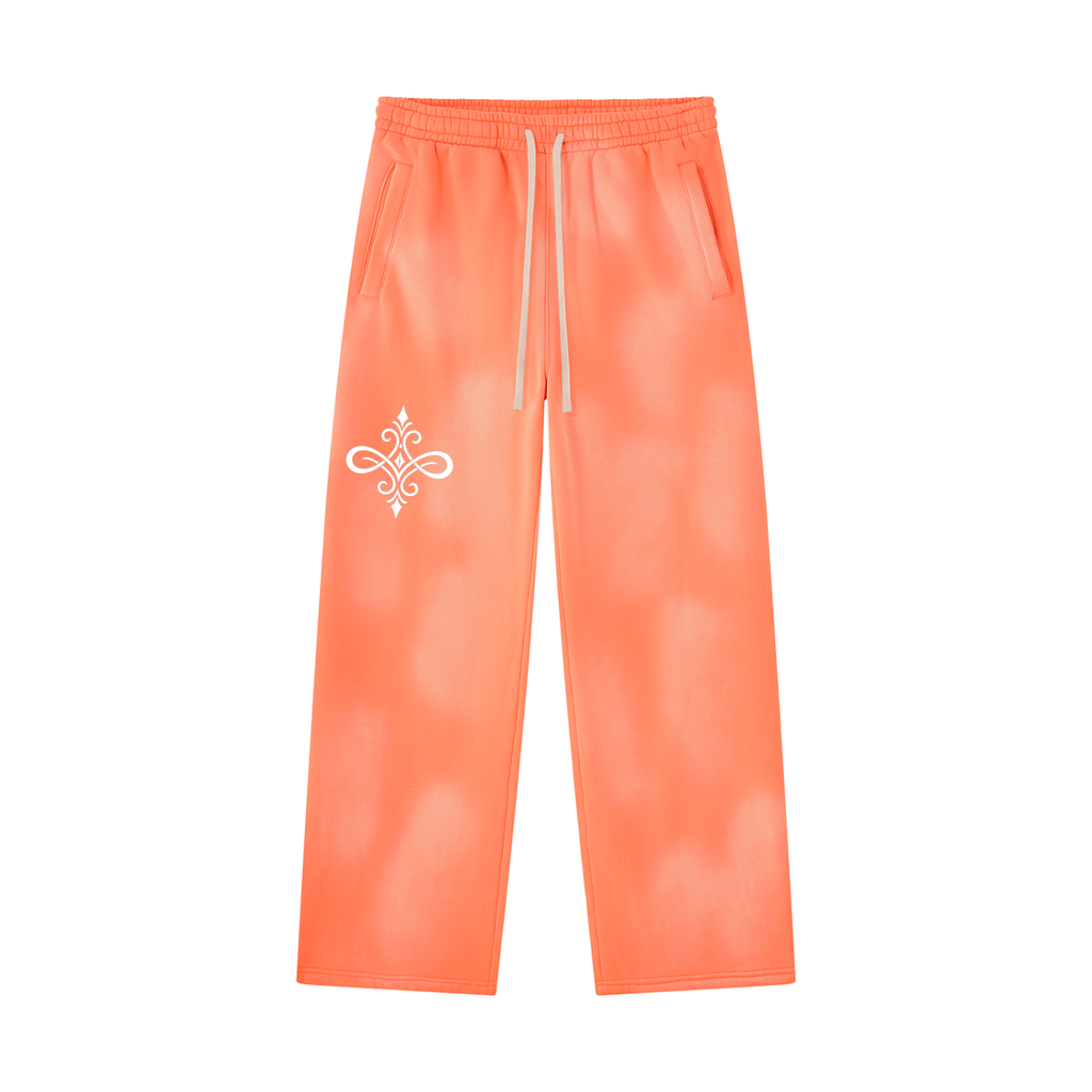 Bright orange tie-dye sweatpants with a white drawstring and a white decorative emblem on the left thigh, shown against a plain white background.