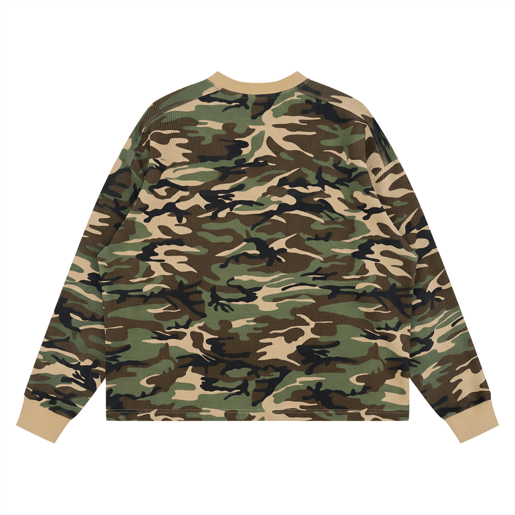 A long-sleeve crewneck sweatshirt featuring a classic woodland camouflage pattern in green, brown, black, and beige, with solid beige ribbed collar, cuffs, and hem, shown flat on a white background.